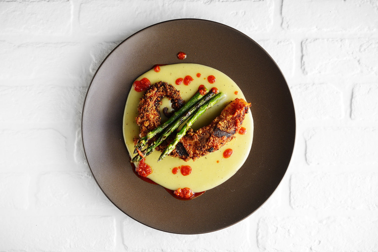 Piovra croccante su crema di patate con asparagi grigliati e salsa alla 'nduja