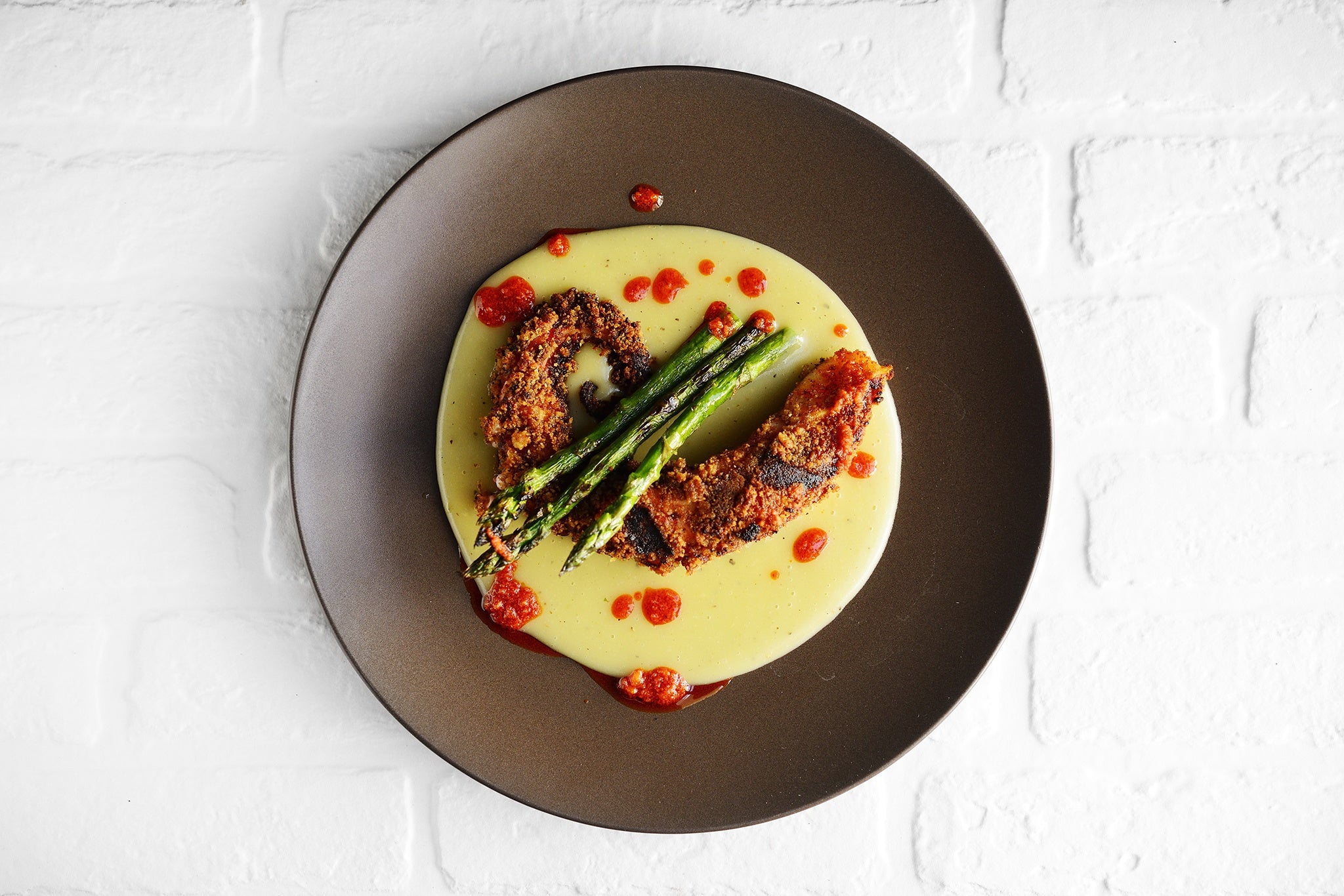 Piovra croccante su crema di patate con asparagi grigliati e salsa alla 'nduja